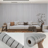 Roll of self-adhesive wood grain wall panels showing a textured gray finish.