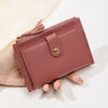 A close-up of a mauve pink women's slim PU leather card holder wallet being held in a hand.