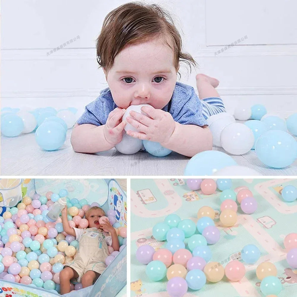 A baby is interacting with a large pile of colorful soft play balls, including blue, white, and pink shades.