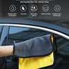 A yellow and gray microfiber car towel is shown being used to clean a car window.