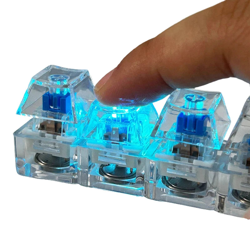 A hand holds a clear plastic LED mechanical keychain fidget toy with blue light and custom keycaps.
