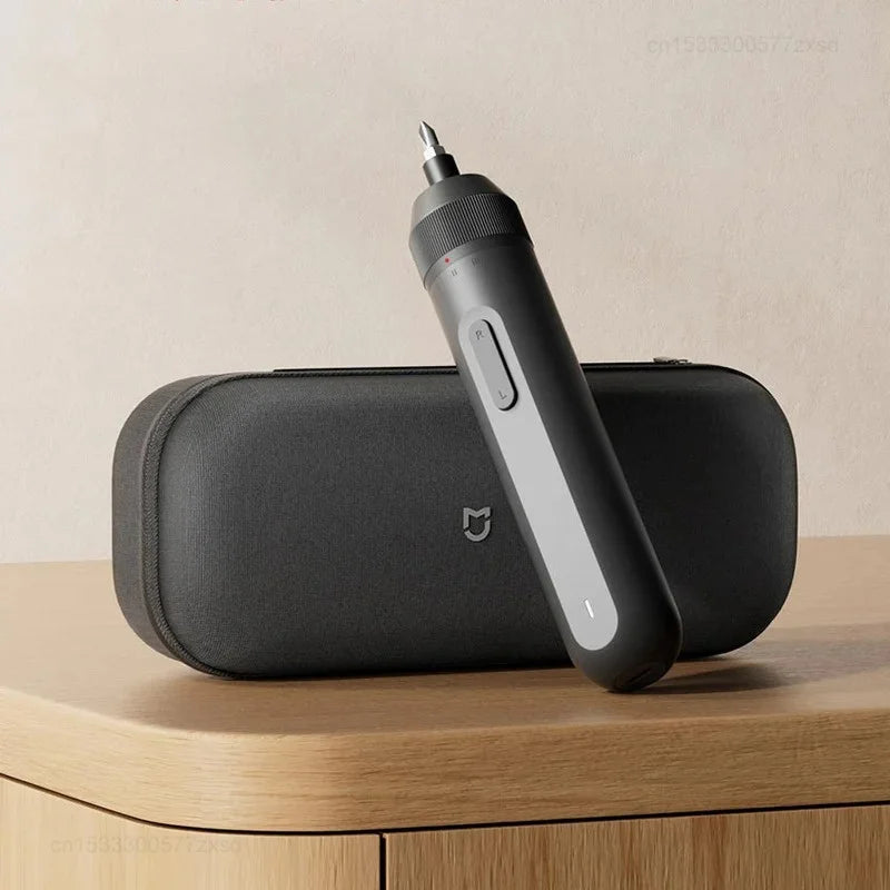 A black electric screwdriver with a silver tip is shown resting on a dark gray case.
