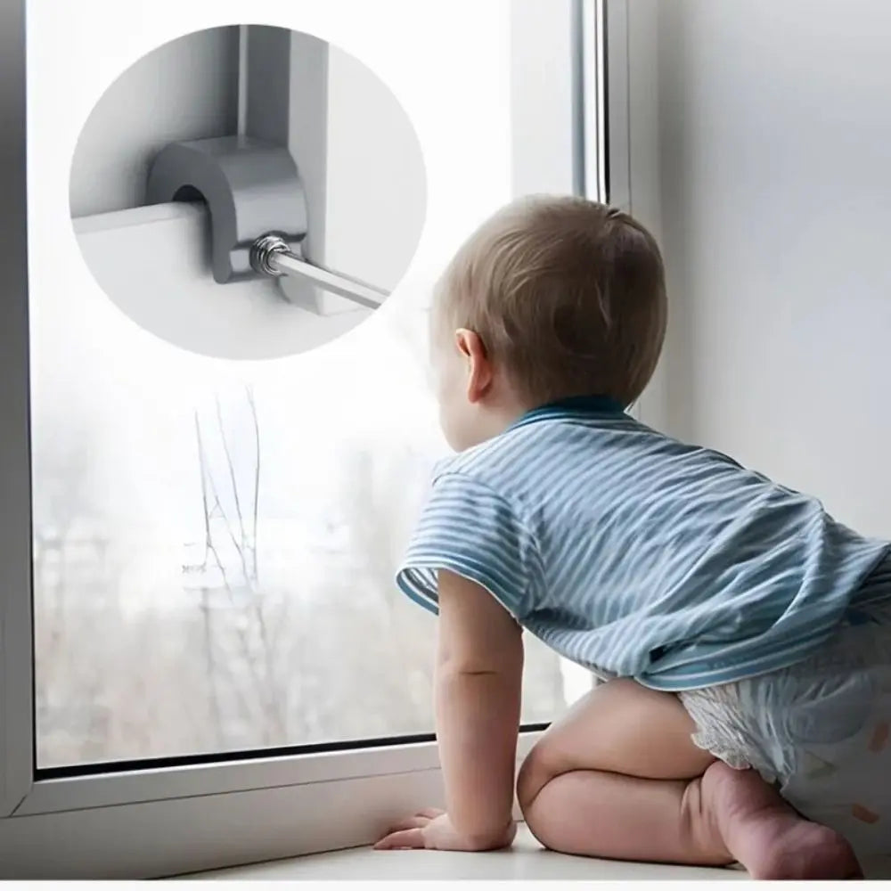 A baby is looking at a window with an adjustable aluminum sliding window lock stopper visible on the frame.