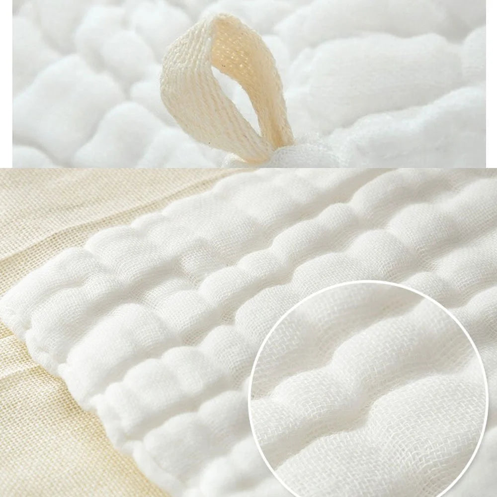 Close-up of soft natural cotton muslin baby washcloths showing their texture and folds.