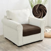 A cream-colored plush velvet stretch sofa seat cover with vertical stripes and a brown cushion.
