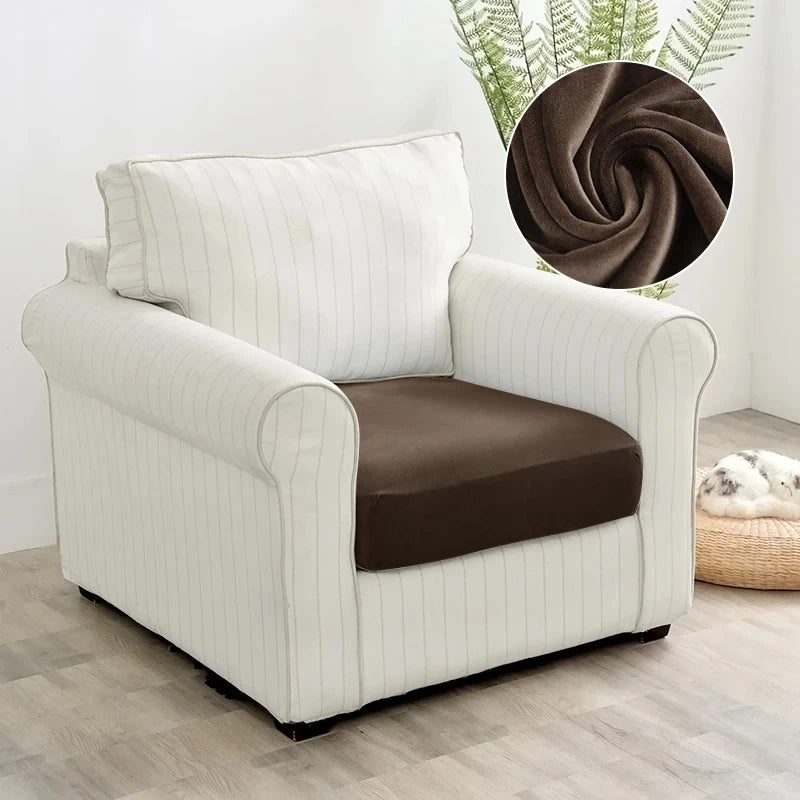 A cream-colored plush velvet stretch sofa seat cover with vertical stripes and a brown cushion.