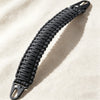 A close-up of a black paracord handle with metal hooks, used for tactical bags and backpacks.