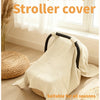 A beige windproof and sun-proof stroller cover is shown draped over a stroller, next to a window.