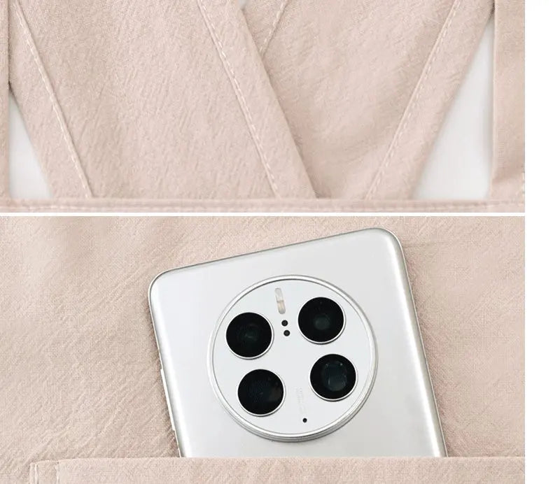 A close-up view of a white smartphone placed inside a light pink cotton kitchen apron.