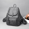 A gray faux leather women's backpack with multiple zippered compartments shown against a light gray background.