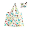 A white reusable shopping tote bag featuring colorful dinosaur and nature-themed prints.