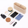 A felt bag organizer containing various small items including a pen, a small notebook, and a smartphone.