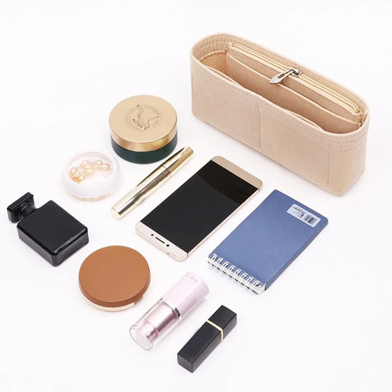 A felt bag organizer containing various small items including a pen, a small notebook, and a smartphone.
