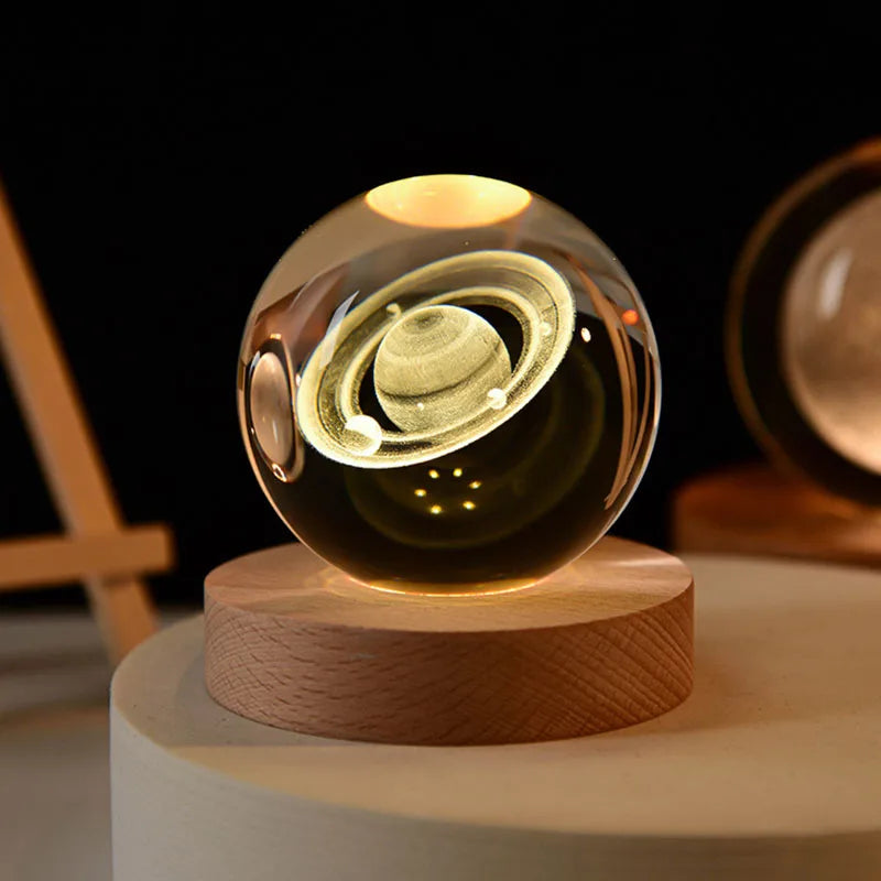 Laser engraved crystal ball night light with a golden swirl inside on a wooden base
