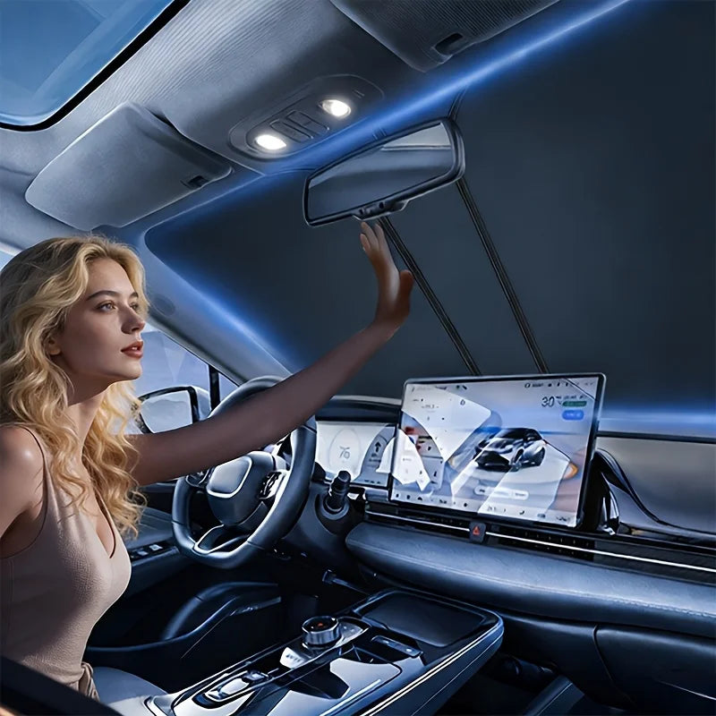 A woman is adjusting a foldable car windshield sunshade in the interior of a car.