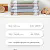 Stack of light green, pink, grey, and khaki cotton swaddle blankets with white bird prints.