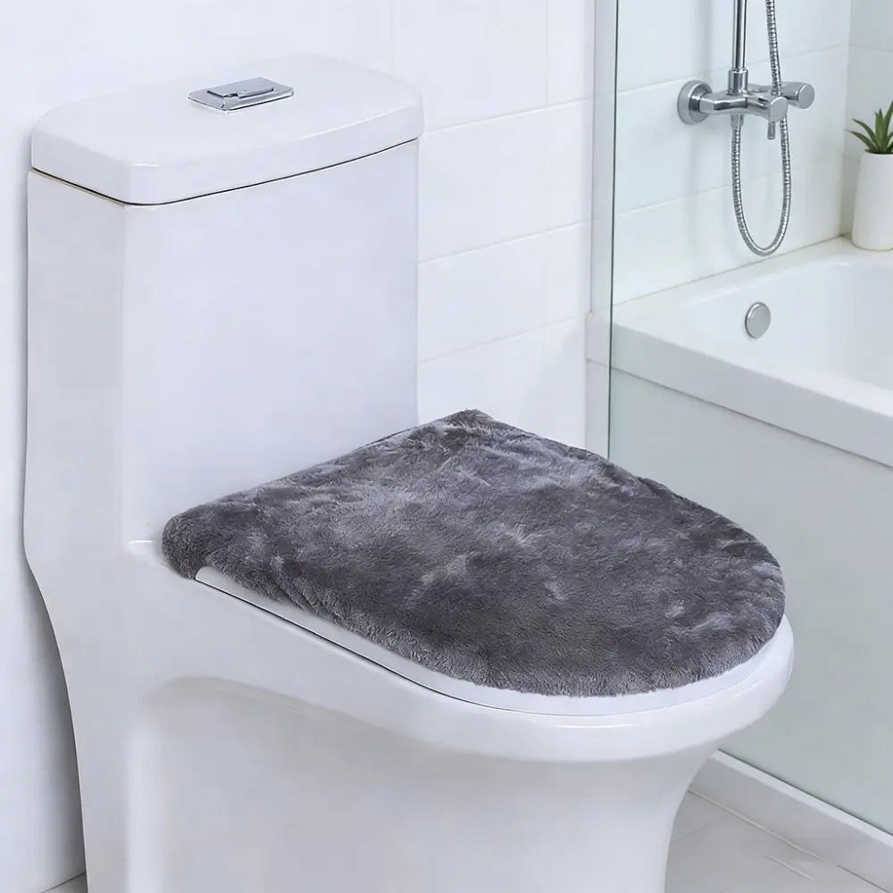 A white toilet features a gray flannel seat cover placed on the seat.