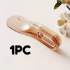 A single, clear, rose gold mattress lifter wedge tool is shown against a light background.