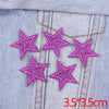 Set of five purple glitter star iron-on embroidered patches on light blue denim fabric