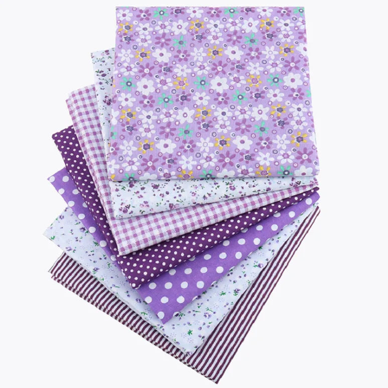 A bundle of purple and white cotton fabric squares featuring various floral dot patterns for patchwork and quilting
