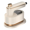 A beige and gold portable handheld garment steamer resting on a white base.