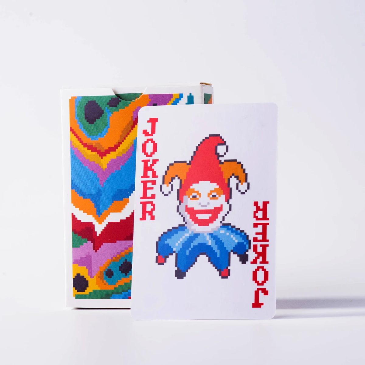 A white card featuring a pixelated Joker face in red and blue, next to a colorful card.