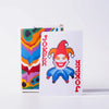 A white playing card featuring a pixelated Joker design with an orange hat and blue outfit.