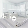White marble peel-and-stick film used as a kitchen backsplash in a modern white kitchen.
