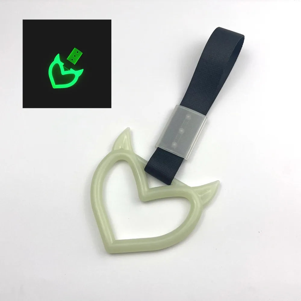 A light green heart-shaped car handle decor with a holographic finish is shown next to its packaging.