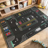 A black play mat depicting a cartoon car traffic route for kids in a nursery or playroom.