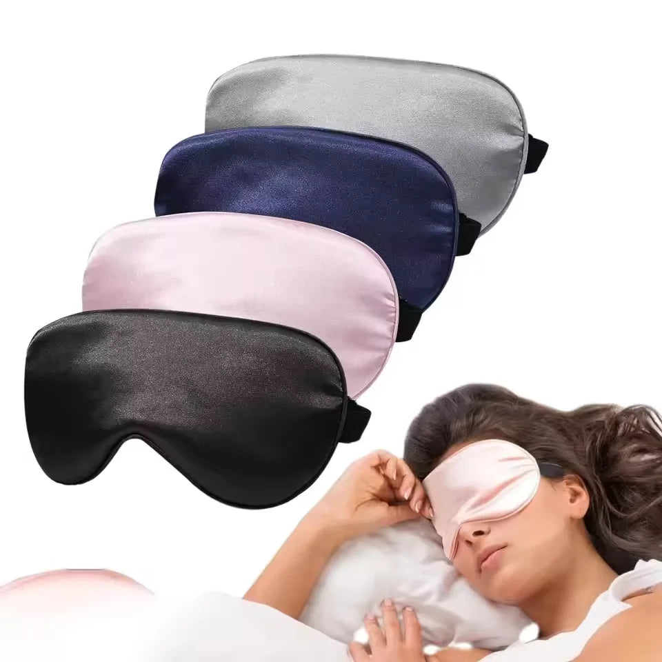 A woman is wearing a pink silk sleep mask while lying down, with several colored masks displayed above her.