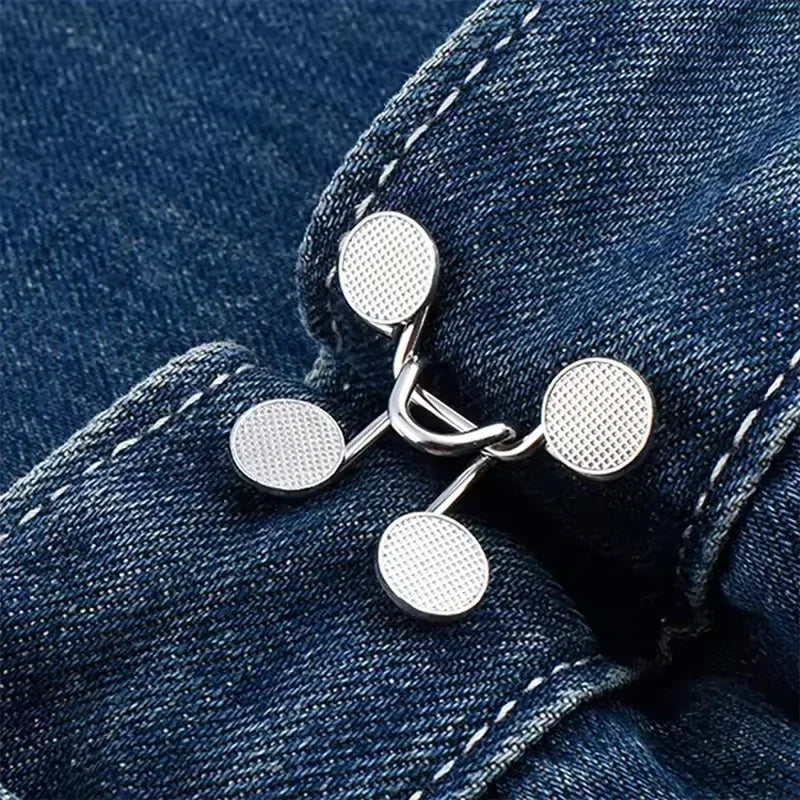 Silver metal button snaps attached to a dark blue denim fabric.