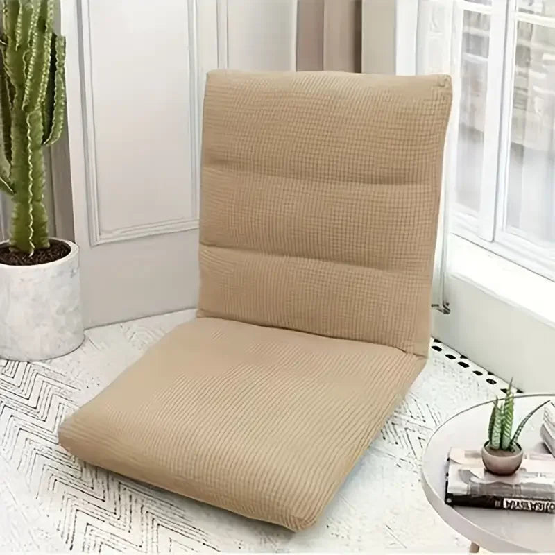 A beige foldable floor sofa cover for a single seat or lounger resting on a white surface.