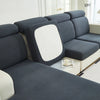 A modern gray Jacquard stretch sofa slipcover with a white accent cushion and non-slip grip.