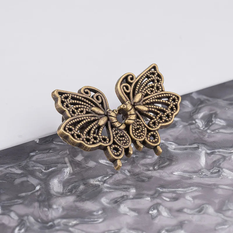 A vintage brass butterfly-shaped no-sew adjustable waist tightener for jeans and skirts.