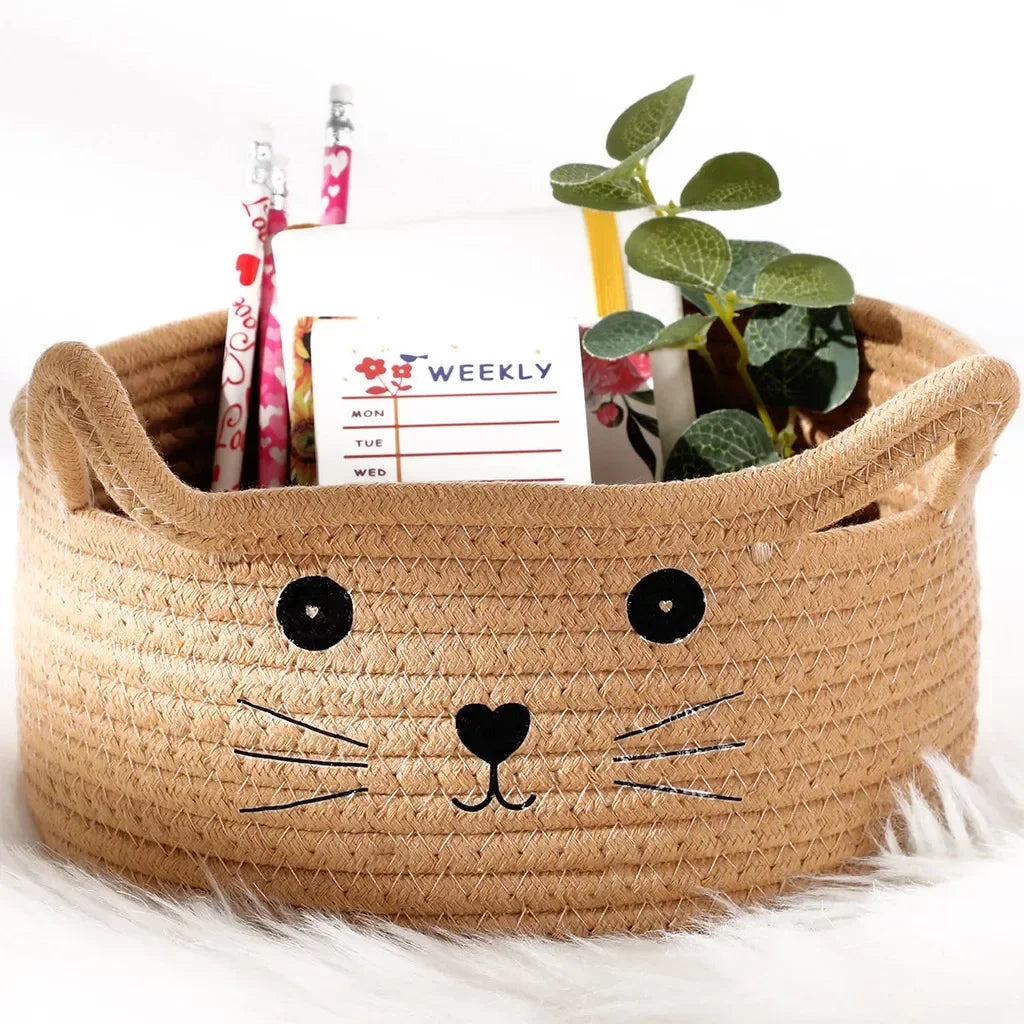 A woven cotton rope storage basket shaped like a fox head holding weekly planner paper and pens.