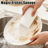 A hand is using a white Magic Eraser sponge to clean a plate in a sink.