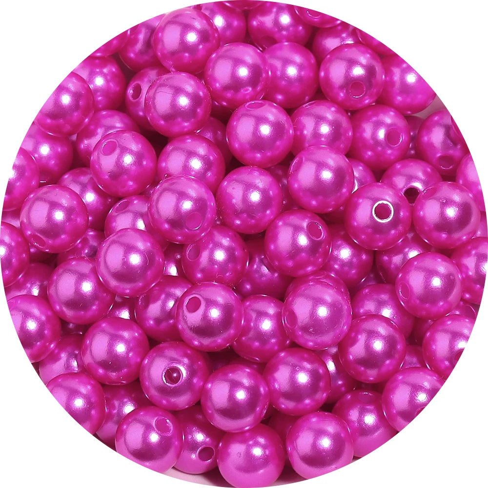 A pile of round, pink imitation pearl beads for jewelry making.