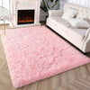 Flauschiger rosa gebundener Teppich vor weißem Kamin und cremefarbigem Sofa