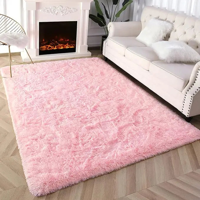 Flauschiger rosa gebundener Teppich vor weißem Kamin und cremefarbigem Sofa