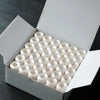 A white box filled with numerous prewound bobbins for home embroidery machines.