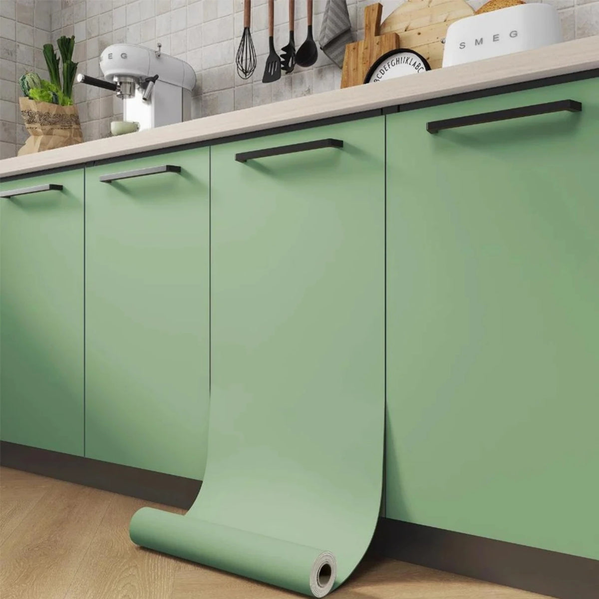 A set of matte green vinyl film rolls for furniture and wall renovation displayed on a kitchen cabinet.