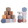 A collection of soft silicone building blocks in various pastel colors and shapes for baby teething and early learning.