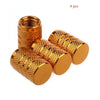 A set of four gold-colored knurled aluminum tire valve caps.