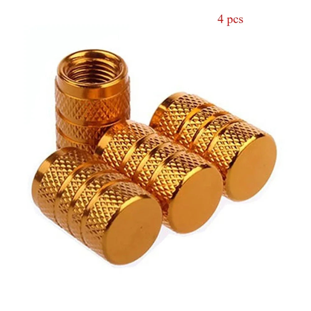 A set of four gold-colored knurled aluminum tire valve caps.