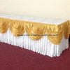 Elegant ice silk table skirt with matching top swag in gold and white for a wedding display.