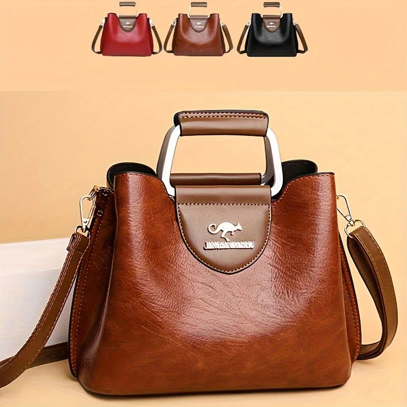 A brown leather vintage crossbody tote bag with a silver hardware detail and multiple pockets shown against a light backgroun