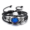 Black leather wrap bracelet featuring a glowing blue zodiac sign charm.