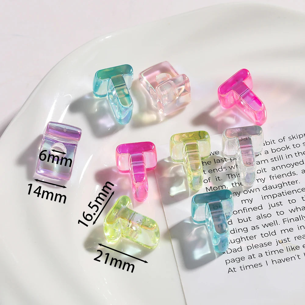 A collection of clear and colored acrylic alphabet beads displayed on a white plate.