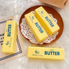 Yellow butter fidget sticks are displayed on a wooden plate with lace, next to another stick.